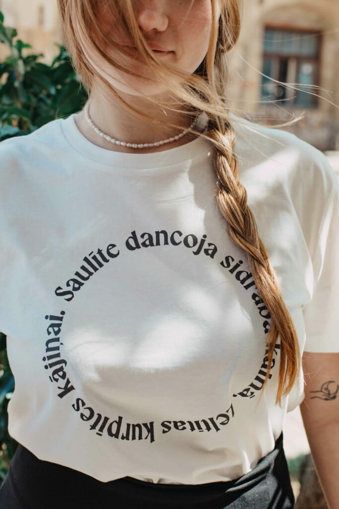M50 Organic Cotton T-shirt | reflective print of a folk song SAULĪTE DANCOJA